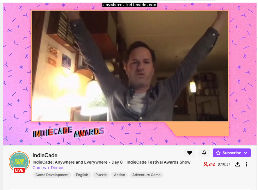 Creative Director of Mutazione, Nils Deneken, is shown on a screencap of a live videostream from the Indiecade 2020 awards raising his hands in celebration