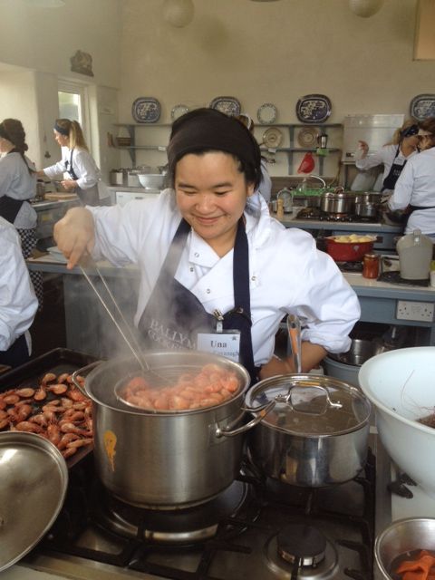 Úna-Minh cooking prawns in front of a pot at Ballymaloe Cookery School